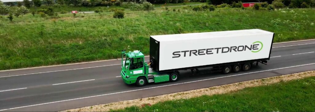 Green autonomous truck with StreetDrone logo delivering parts to a regional distribution centre